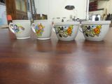 four coffee cups sitting on a table in a room