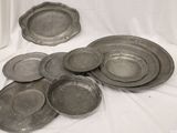 a lot of silver plates sitting on a white cloth