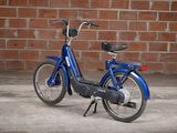 an image of a blue bike parked in front of a brick wall