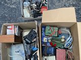 two boxes full of electronic devices on the ground