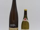 deux bouteilles de vin posées l'une à côté de l'autre sur une surface blanche