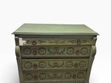 une commode verte dont les tiroirs sont ornés de motifs floraux