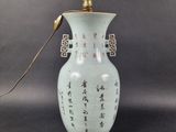 a white vase with asian writing on it on a table