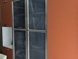 salle à manger avec des placards orange, des chaises blanches et un sol en carrelage blanc