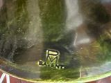 a glass vase with a green lid sitting on a table