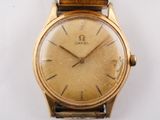 an image of a gold wrist watch on a white surface