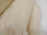a close up of a white blanket on a white surface