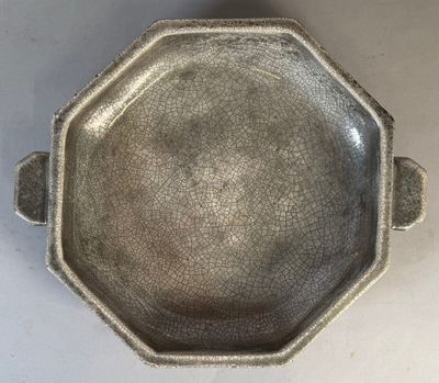 a silver bowl with a handle on a table