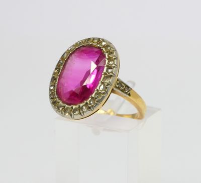 a close up of a pink stone ring on a white surface