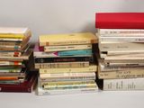 many books stacked on top of each other on a table