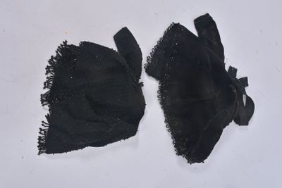 deux morceaux de tissu noir sur une surface blanche