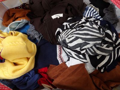 un panier rempli de vêtements posé sur un lit