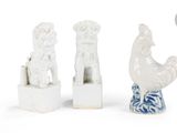 trois figurines représentant un coq et une poule, posées sur un socle