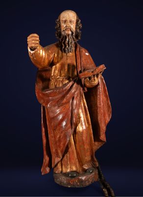 une vieille statue représentant un homme barbu muni d'une canne