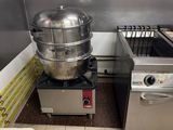une cuisine avec un grand saladier posé sur la cuisinière, à côté d'un four encastré