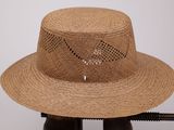 un chapeau de paille posé sur un support en bois