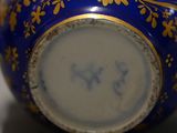 a blue vase with gold decoration on it on a table