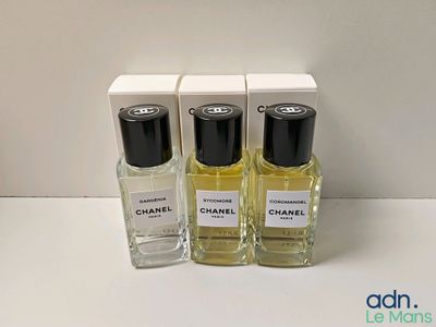 trois flacons de parfum Chanel posés sur une table