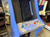 une photo d'une borne d'arcade bleue et blanche dans un garage
