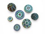 six different types of glass beads on a white surface