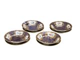 quatre assiettes violettes et blanches ornées de fleurs, posées sur un fond blanc