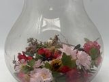 a glass vase with flowers inside of it on a table