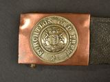 an old belt with a metal buckle with a coat of arms on it
