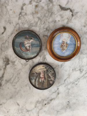 trois miniatures représentant une femme et un homme sur une surface en marbre