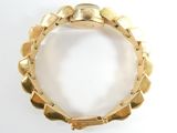an image of a close up of a gold bracelet on a white surface
