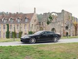 a black car that is parked in front of a castle