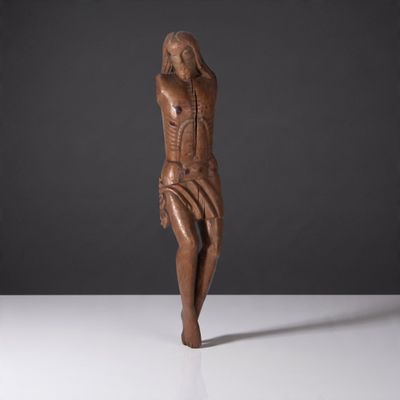 une sculpture en bois représentant une femme se tenant la tête entre les mains