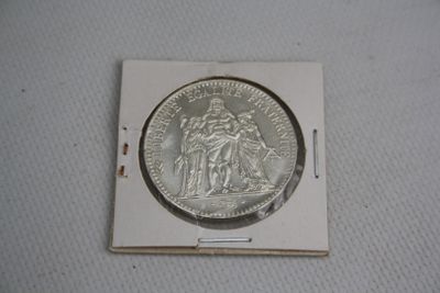 une pièce d'argent sur laquelle figurent les portraits d'une femme et d'un homme