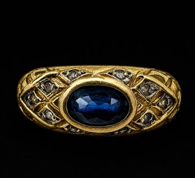 gros plan d'une bague en or avec une pierre bleue