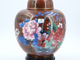 a vase with a lid that has flowers painted on it