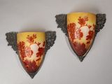 two wall sconces that have red and yellow designs on them