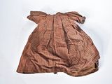 an old brown dress laying on a white surface next to a pair of shoes