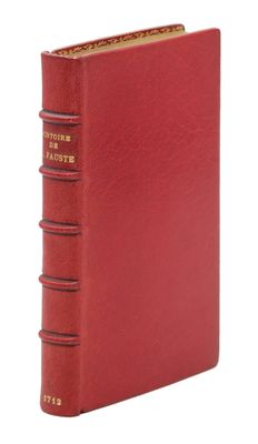 un livre rouge avec une reliure dorée sur la couverture