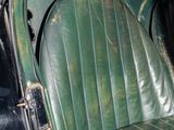 a green seat in the back of an old car