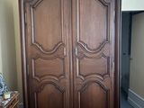 une grande armoire en bois dans le coin d'une pièce