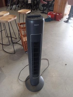 a black tower fan sitting on the floor in a room