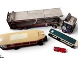 trois camions miniatures et un bus posés sur une surface blanche