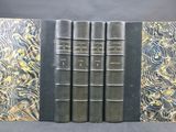un lot de quatre livres aux couvertures dorées et noires