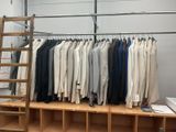 a rack of clothes and a ladder in a room