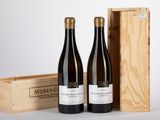 deux bouteilles de vin dans un coffret en bois à côté d'une bouteille de vin
