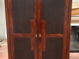 une armoire en bois à deux portes, dont l'une est vitrée