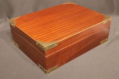an image of a wooden box with brass trimming on it