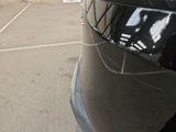 a black car parked in a parking lot next to a building