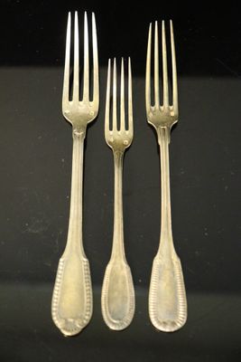 trois fourchettes et deux cuillères posées sur une surface noire