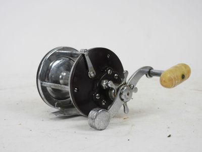 a close up of a fishing reel on a white surface