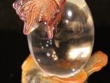 a glass ball with a butterfly on top of it